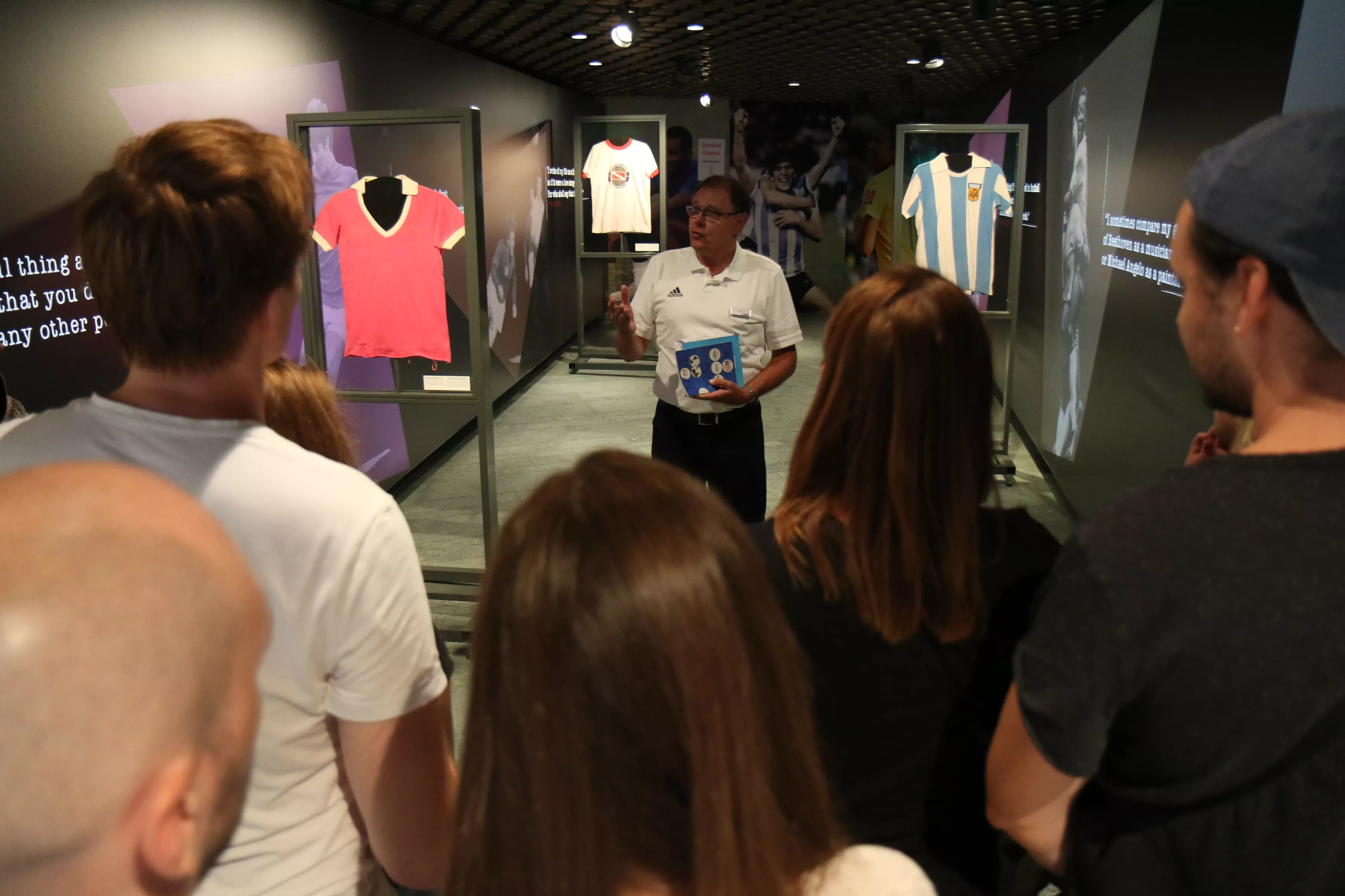 Museum guide giving tour to visitors in jersey exhibition